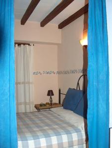 1 dormitorio con 1 cama con cortinas azules en Studio with balcony and wifi at Robledillo de Gata, en Robledillo de Gata