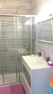 y baño con ducha y lavamanos. en Comfortable apartment in Praia da Rocha 70 m² with sea view 4 pers, en Portimão