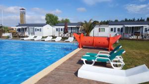 Una piscina con tumbonas al lado de una casa. en Charming House in Burinhosa, Pataias with Shared Pool, en Burinhosa