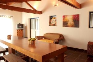 a living room with a wooden table and a couch at 3 bedrooms house with shared pool furnished terrace and wifi at Burinhosa Pataias 5 km away from the beach in Burinhosa