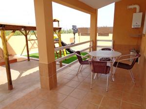 un patio con tavolo e sedie sul balcone. di 4 bedrooms villa with sea view private pool and enclosed garden at Benifayo a Benifayó