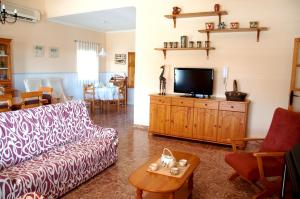 un soggiorno con divano e TV di 4 bedrooms villa with sea view private pool and enclosed garden at Benifayo a Benifayó