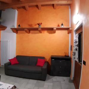 een woonkamer met een bank en een plank aan de muur bij One bedroom appartement with enclosed garden and wifi at Aymavilles 7 km away from the slopes in Aymavilles
