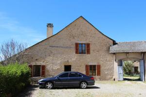 a car parked in front of a brick building at Appartement spacieux avec vue sur les montagnes à Espalion in Espalion