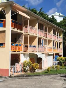 ein großes Apartmenthaus mit Balkonen und Tischen in der Unterkunft Studio a Sainte Anne a 130 m de la plage avec terrasse in Sainte-Anne
