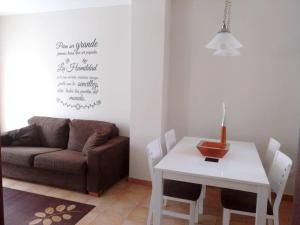 uma sala de estar com uma mesa e um sofá em 2 bedrooms house with shared pool enclosed garden and wifi at Suances 5 km away from the beach em Suances