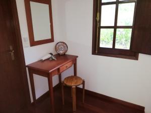 カマシャにある2 bedrooms house with furnished garden and wifi at Camachaの木製テーブル、スツール、窓が備わる客室です。