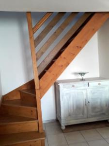 eine Holztreppe in einem Zimmer mit einer weißen Wand in der Unterkunft Maison de 2 chambres a Clion in Clion