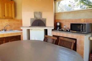 a kitchen with a table and a microwave oven at Maison charmante à Martigues avec jardin et climatisation in Martigues +7 photos