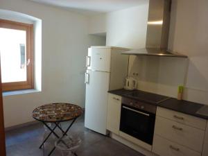 cocina con nevera, fogones y mesa en Appartement d'une chambre avec vue sur la mer a Bonifacio, en Bonifacio