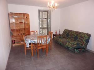 sala de estar con mesa, sillas y sofá en Appartement d'une chambre avec vue sur la mer a Bonifacio, en Bonifacio