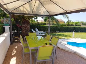 uma mesa e cadeiras sob um guarda-sol num pátio em 3 bedrooms villa with private pool enclosed garden and wifi at Linares em Jaén