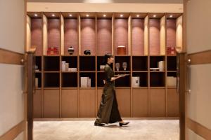 Una mujer camina por una habitación en una tienda en Foreign Trade Centre C&D Hotel,Fuzhou, en Fuzhou