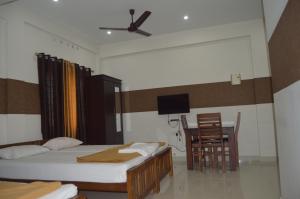 a bedroom with two beds and a table and chairs at Coral Homes in Cochin