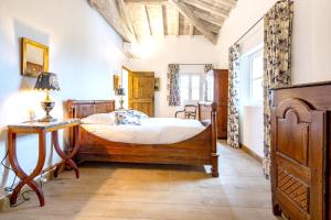Schlafzimmer mit einem Holzbett und einem Tisch in der Unterkunft Villa de 6 chambres avec piscine privee jardin amenage et wifi a Cahors in Cahors