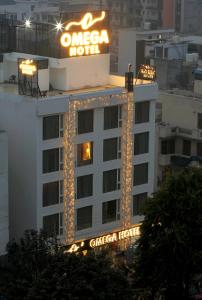 a onezona hotel with a neon sign on top of it at Hotel Omega - Gurgaon Central in Gurgaon