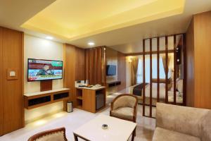 a hotel room with a bed and a television at Hotel Omega - Gurgaon Central in Gurgaon
