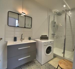 a bathroom with a washing machine and a sink at Superbe T2 de 45m² en hyper centre in La Rochelle +16 photos