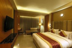 a bedroom with a large bed in a hotel room at Hotel Omega - Gurgaon Central in Gurgaon