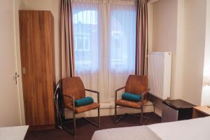 pokój hotelowy z 2 krzesłami i oknem w obiekcie Hotel Eckhardt w mieście Uithuizen