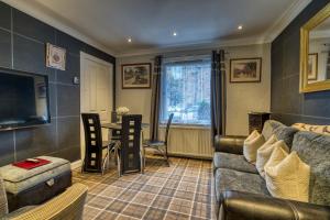 a living room with a couch and a table at Pitfaranne Guest House in Inverness