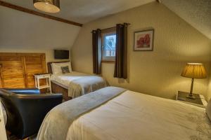 a room with two beds and a chair and a window at Pitfaranne Guest House in Inverness