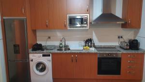 a small kitchen with a washer and a microwave at Las Nieves de Lillo in Puebla de Lillo