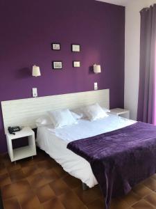 sypialnia z dużym łóżkiem i fioletową ścianą w obiekcie Hotel Plaza Miami - Sólo Adultos w mieście Miami Platja