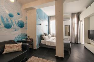 テルアビブにある27Montefiore - Urban ApartHotel TLVのベッドとソファ付きのホテルルーム