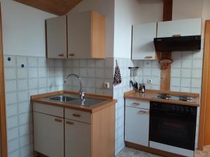 a kitchen with a sink and a stove at Apartment Utschneider-Holzer in Bad Bayersoien