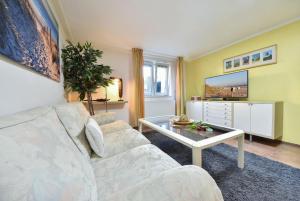 een woonkamer met een witte bank en een tafel bij Haus Thalia 1 - Nestchen in Ahlbeck