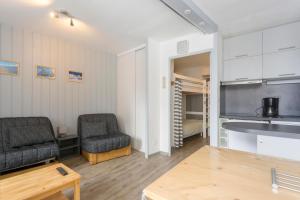 a living room with two chairs and a kitchen at Le Chamois - A 20m des pistes ! in Saint-Martin-de-Belleville +4 photos