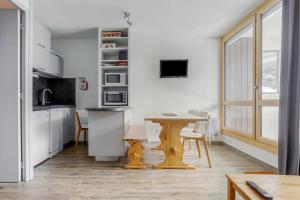 a kitchen with a wooden table and a dining room at Le Chamois - A 20m des pistes ! in Saint-Martin-de-Belleville