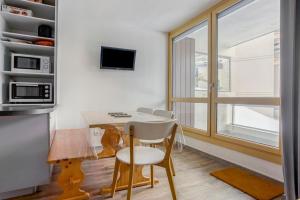 a small kitchen with a table and chairs and a window at Le Chamois - A 20m des pistes ! in Saint-Martin-de-Belleville