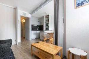 a living room with a couch and a table at Le Chamois - A 20m des pistes ! in Saint-Martin-de-Belleville