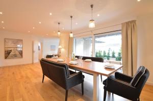 a dining room with a large wooden table and chairs at Arnikas Hues in Wyk auf Föhr