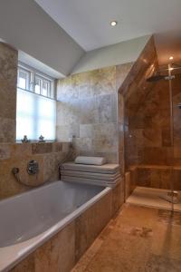 a large bathroom with a tub and a shower at Friesenliebe in Borgsum