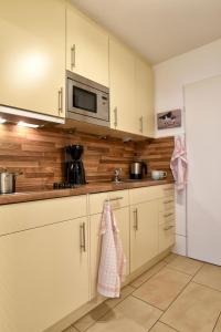 a kitchen with white cabinets and a microwave at Nordland Appartements Wohnung Aerö in Wyk auf Föhr