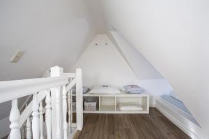a room with a staircase with a bed in a attic at Haus am Turm in Wyk auf Föhr