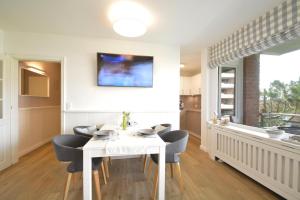 cocina y comedor con mesa blanca y sillas en Haus Habel Wohnung 18, en Wyk auf Föhr