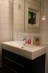 ein weißes Waschbecken im Bad mit Spiegel in der Unterkunft Skomakergarden in Ulsteinvik