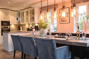 a kitchen with a dining table with chairs and lights at Meggis Hues in Westerland (Sylt)