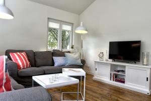 uma sala de estar com um sofá e uma televisão de ecrã plano em Hoernchens Nest em Wyk auf Föhr
