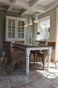 a dining room with a white table and chairs at Jettes Hus in Midlum
