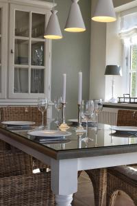 una mesa de comedor con copas de vino y velas en Jettes Hus, en Midlum
