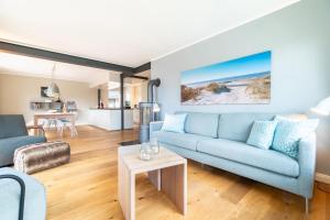 a living room with a blue couch and a table at Haus Westerheide in Nieblum