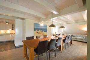 a dining room with a wooden table and chairs at Reethus Doerpsend Haus 1 in Midlum