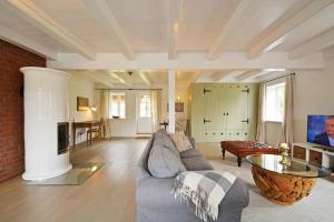 a living room with a couch and a table at Reethus Doerpsend Haus 2 in Midlum