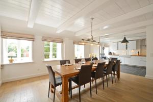 une salle à manger avec une grande table et des chaises en bois dans l'établissement Reethus Doerpsend Haus 2, à Midlum