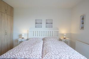 1 Schlafzimmer mit einem weißen Bett und 2 Tischen in der Unterkunft Hafenkante in Husum